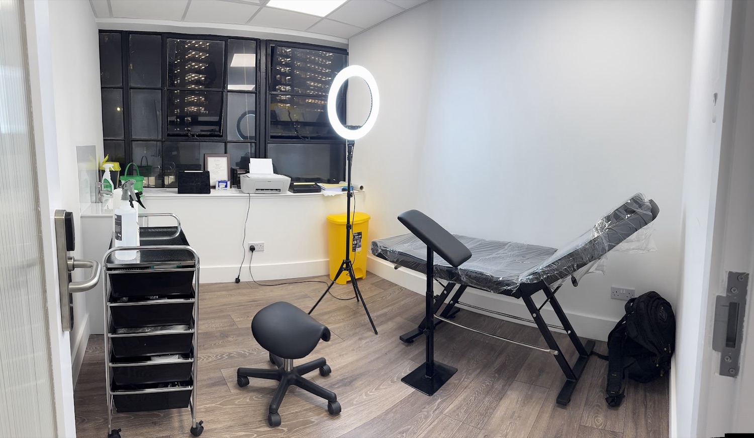 The private tattoo room at Top Notch, Shoreditch — clean white walls, tattoo bed freshly wrapped, ring light and a tidy workstation